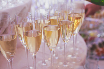 Line of different colored alcohol cocktails on a decorated catering banquet table on a party