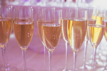 Line of different colored alcohol cocktails on a decorated catering banquet table on a party