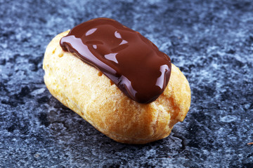 Traditional French dessert. Eclair with chocolate icing. Pastery concept
