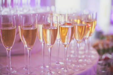 Line of different colored alcohol cocktails on a decorated catering banquet table on a party