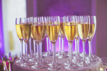 Line of different colored alcohol cocktails on a decorated catering banquet table on a party
