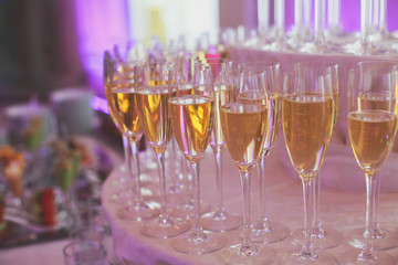 Line of different colored alcohol cocktails on a decorated catering banquet table on a party