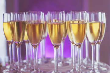 Line of different colored alcohol cocktails on a decorated catering banquet table on a party