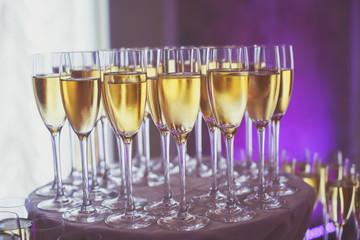 Line of different colored alcohol cocktails on a decorated catering banquet table on a party