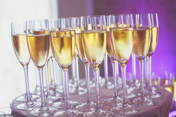 Line of different colored alcohol cocktails on a decorated catering banquet table on a party