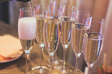 Line of different colored alcohol cocktails on a decorated catering banquet table on a party
