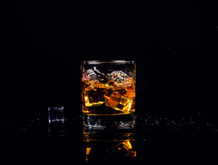 Isolated shot of whiskey with splash on black background