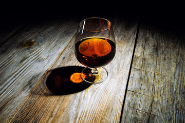 glass with cognac on a wooden background
