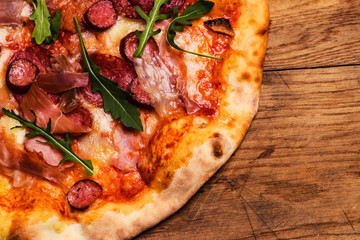 Hot pizza on a rustic wooden table.