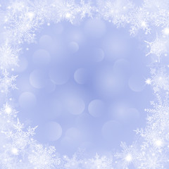 Christmas background with frame of snowflakes and bokeh effect in light blue