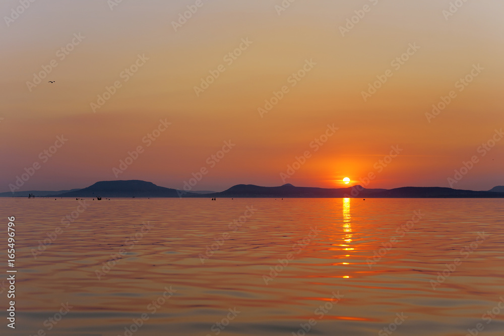 Wall mural sunset wallpaper of lake balaton with badacsony mountains in the bakcground, in hungary