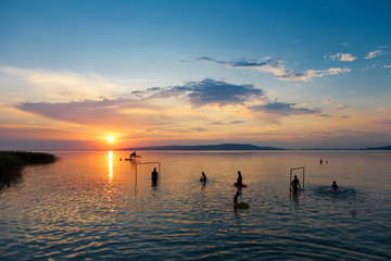 Bather's silhouettes at sunset in Lake Balaton, Hungary
