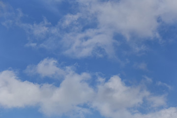 Blue sky with bright white clouds in daylight.