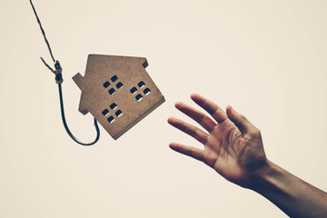 A house on a fish hook / Risks and negative sides of buying a house concept