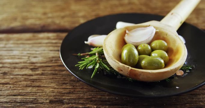 Ingredients olive and garlic kept on a black plate