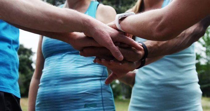 Athletics forming hand stack in the park