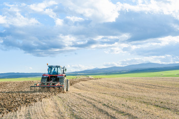 agricultural machinery in the foreground carrying out work in the field.
