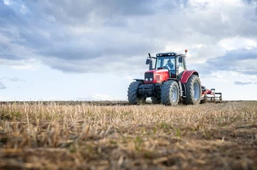 Fototapete Traktor Landmaschinen im Vordergrund, die Arbeiten auf dem Feld ausführen.