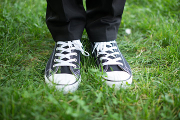 the people in the Park feet in sneakers on green grass in Sunny day
