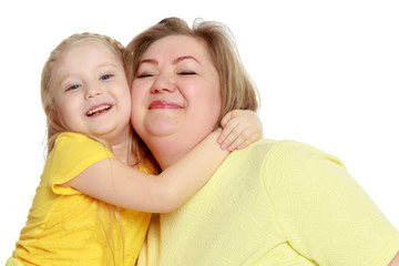 A happy mother hugs her beloved daughter.