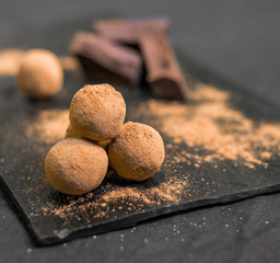 Chocolate truffle candy coated in cocoa powder against black background