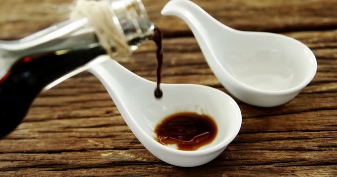 Soy sauce being poured into appetizer spoon