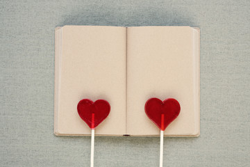 Two heart-shaped lollipops on an old diary
