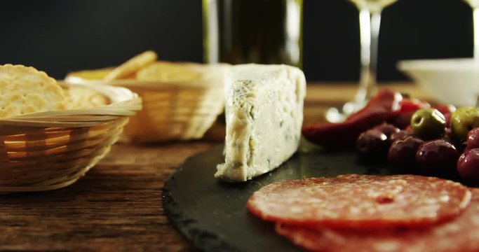 Cheese, olive and salami on table