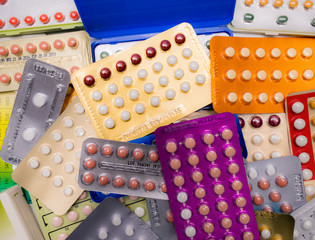 Piles of colorful birth control pills with modern packaging