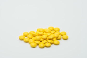 Yellow tablet pills on white background