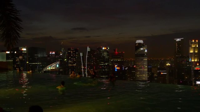 night time hotel rooftop swimming pool tourist panorama downtown 4k singapore
