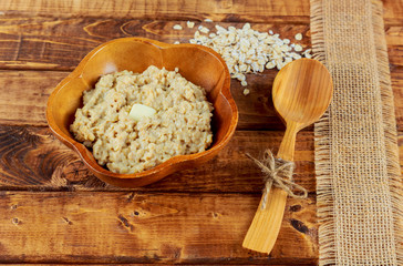 Oatmeal in black bowl and near on dark wooden table
