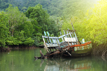 Fototapeta na wymiar Old Sink fishing boat dock dead along mangrove canal river forest jungle