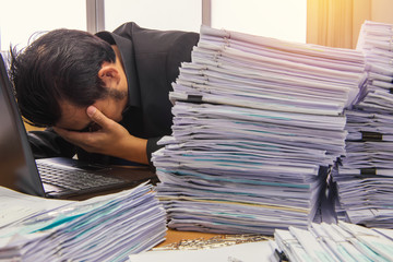 documents on desk stack up high waiting to be managed