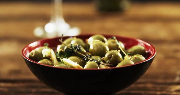 Bowl of green olive tapas and wine