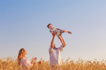 happy family in cereal field at sunset