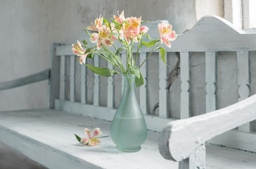 Alstroemeria in vase onold wooden bench