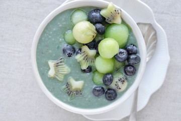 Blue spirulina smoothie bowl with melon, kiwi fruit and blueberries