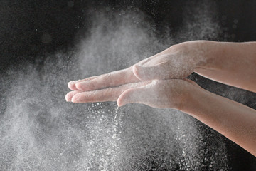 Fototapeta na wymiar Flour hands on a black background
