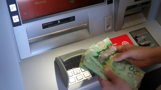 Woman withdrawing money at ATM machine with 4k resolution