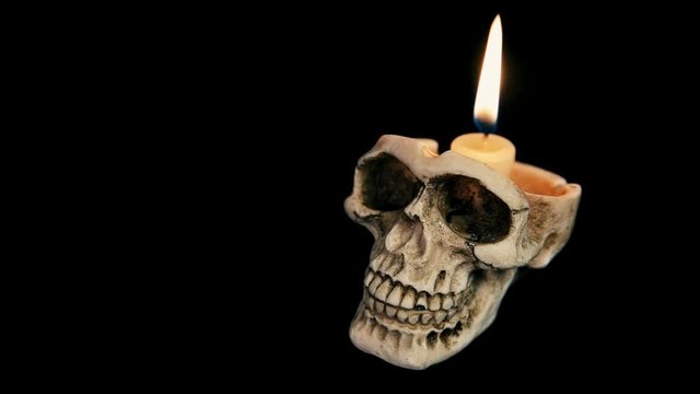 skull with a burning candle on a black background