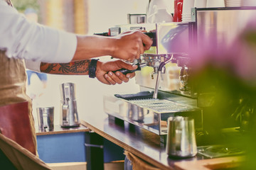 Close up image of a man preparing coffee late.