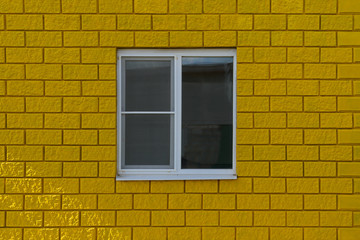 Plastic closed window with a reflection on a brightly yellow wall