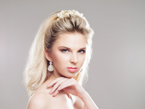 Portrait of gorgeous blond with a beautiful headband on a grey background.