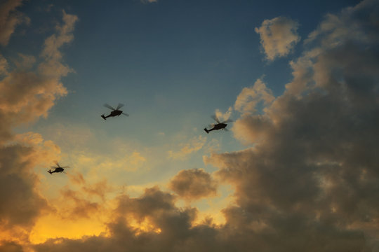 helicopters flying on a background of sunset sky. Three helicopters in the sky