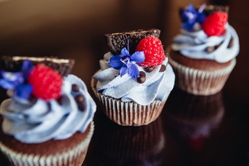 Beautiful and tasty muffins with raspberries and flowers