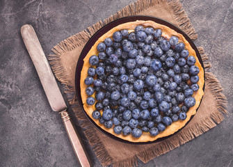 Blueberry tart with icing sugar top view