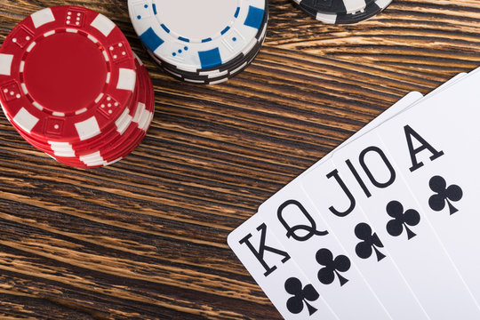 set of winning poker cards on a wooden table with poker chips