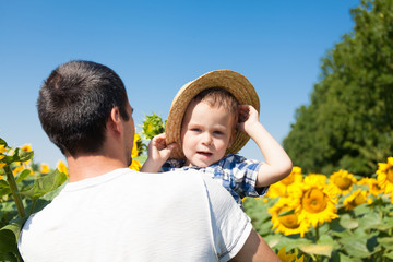 Father and son in sunflower field