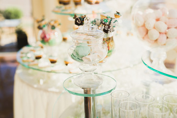 Delicious sweets on wedding candy buffet with desserts, cupcakes